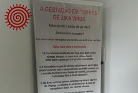 Poster in a private fertility clinic in São Paulo, Brazil, 2018. The poster begins: 'Pregnancy in times of Zika virus. To postpone or not the dream of being a mother? Is it really necessary?’. Image by the author.